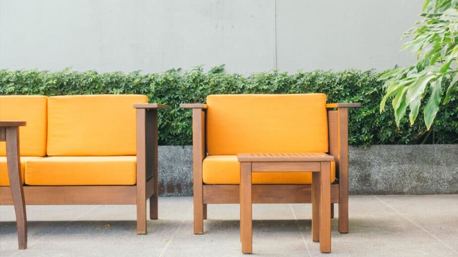 Dřevěný zahradní nábytek s oranžovými podsedáky. Inspirace pro správnou péči a tipy, jak vyčistit podsedáky, aby zůstaly dlouho krásné